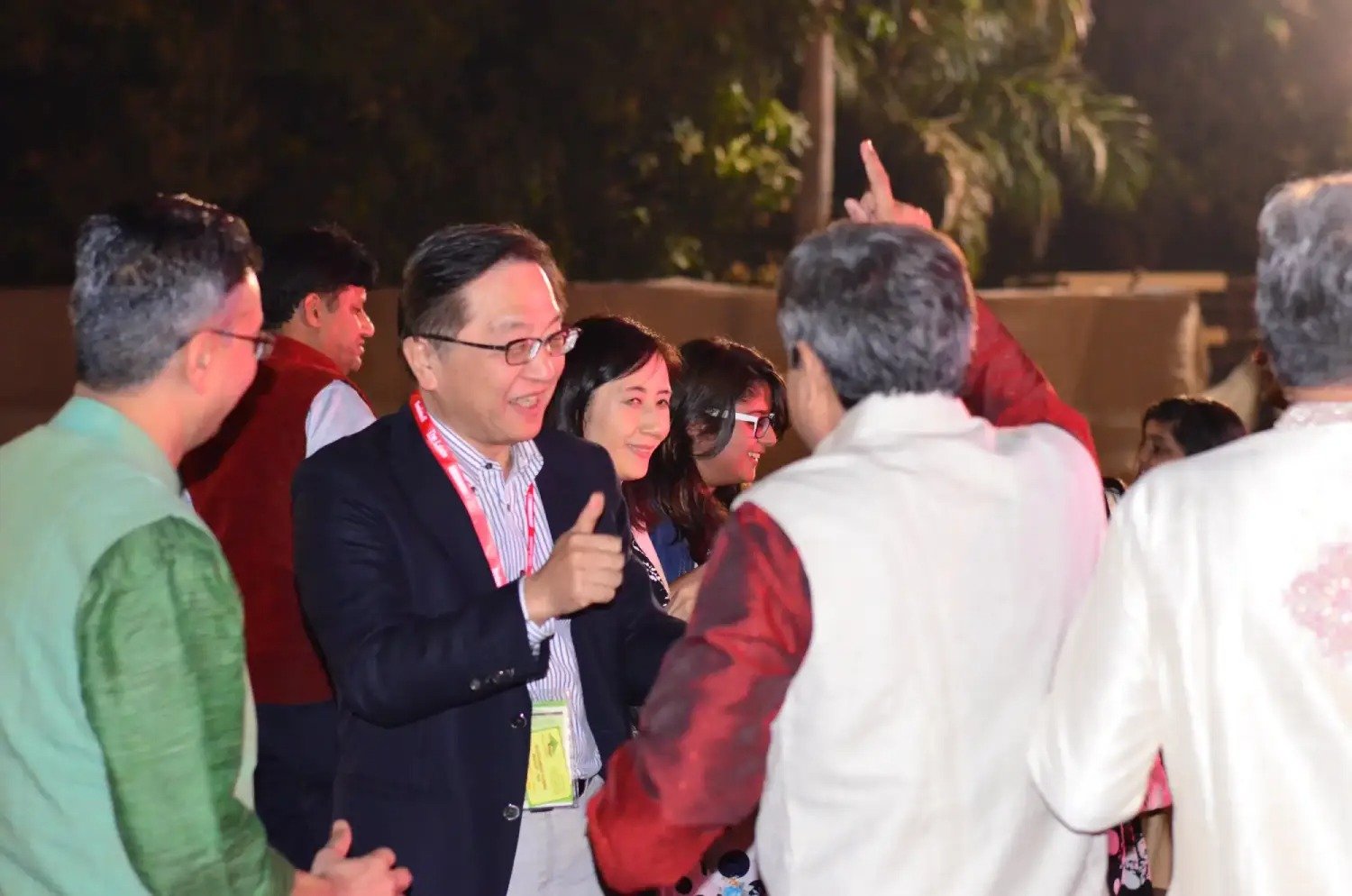 Group of men posing with large cartoon character inflatable figures at night outdoors