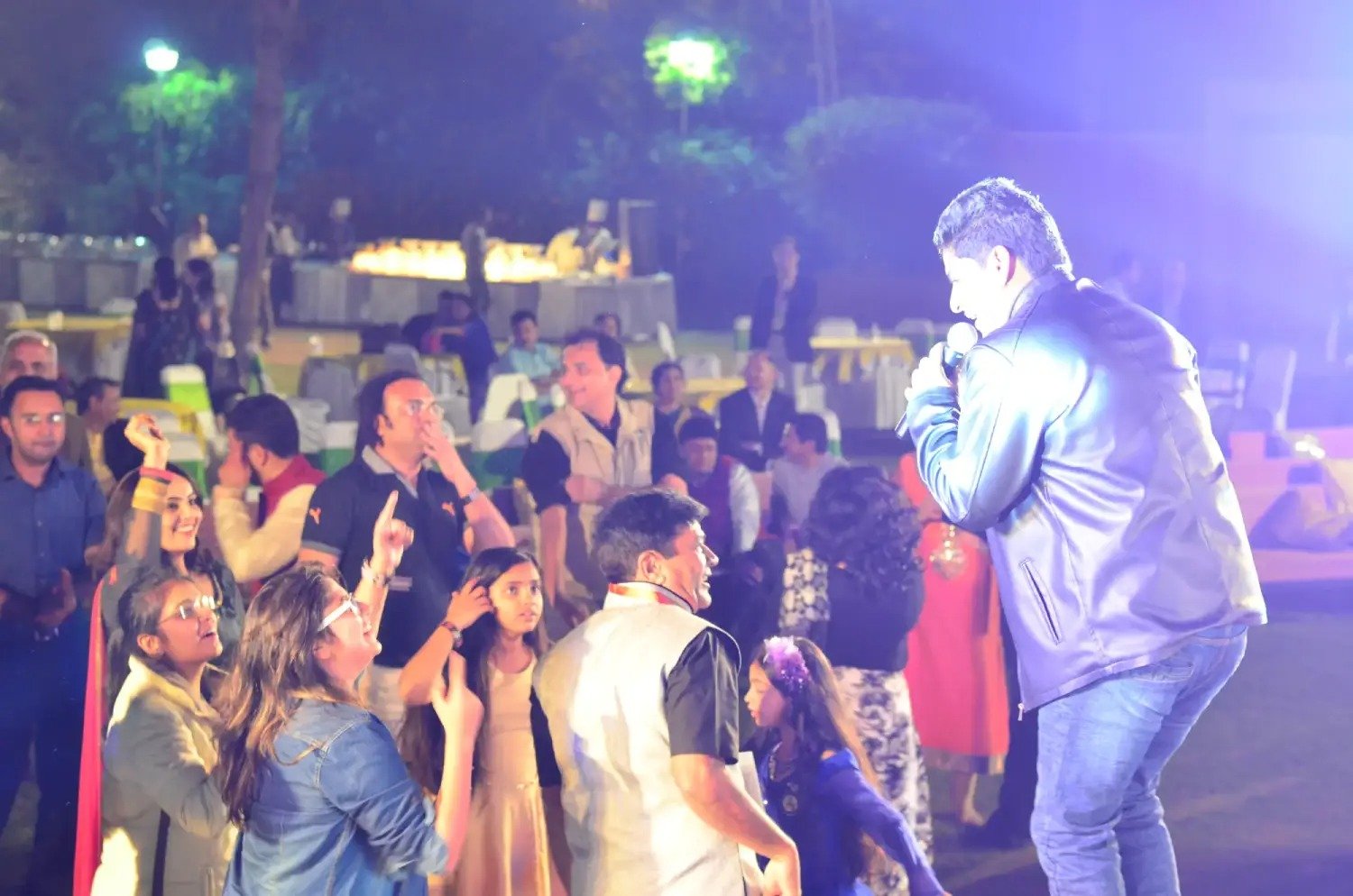 Men lighting ceremonial lamp at event with ITT banner in background